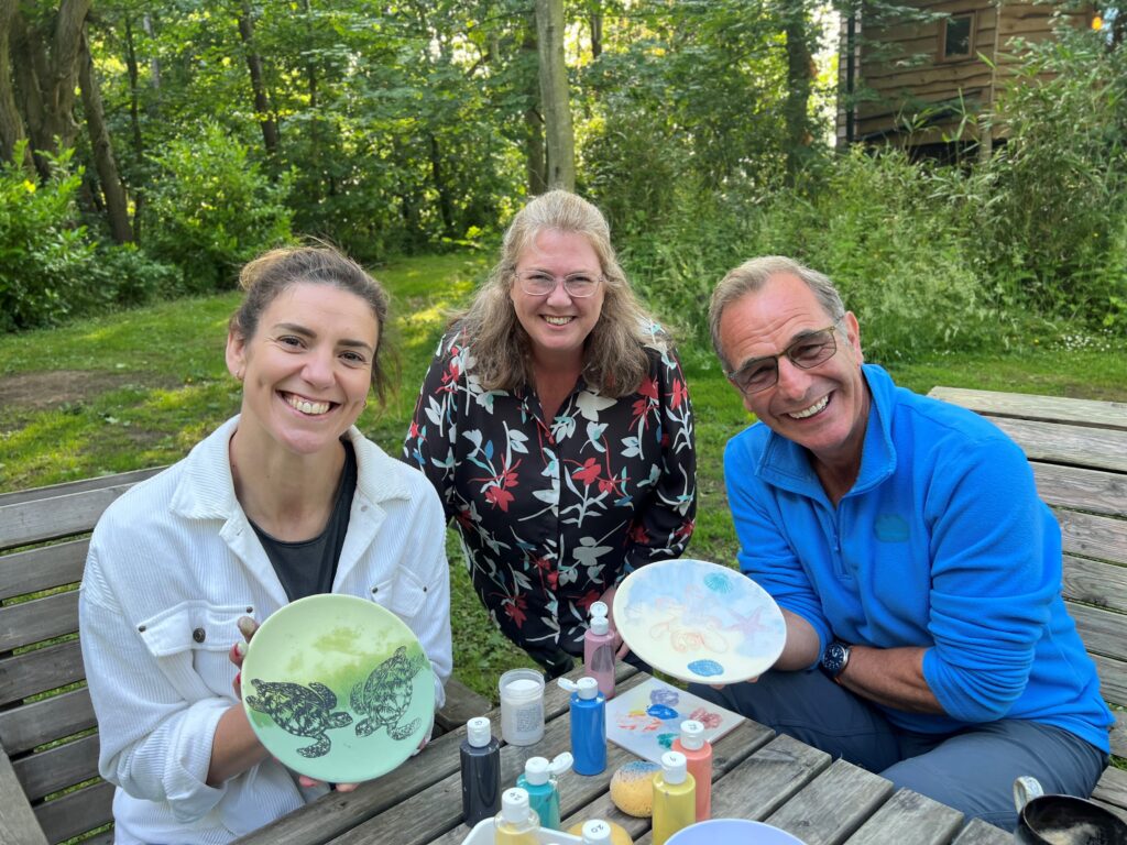 Robson Green and Sarah Hunter holding their finished pottery painting.
